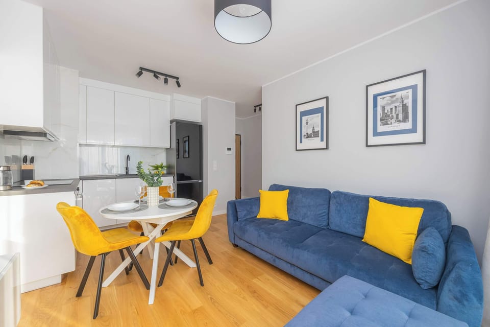 Focus on the stylish decor in the living area, with bold color contrasts between the sofa and accessories.