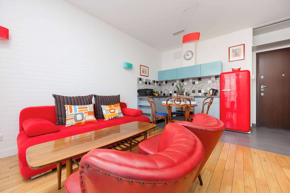 Stylish living room with a sofa bed, TV and a fully equipped kitchenette with dining area.