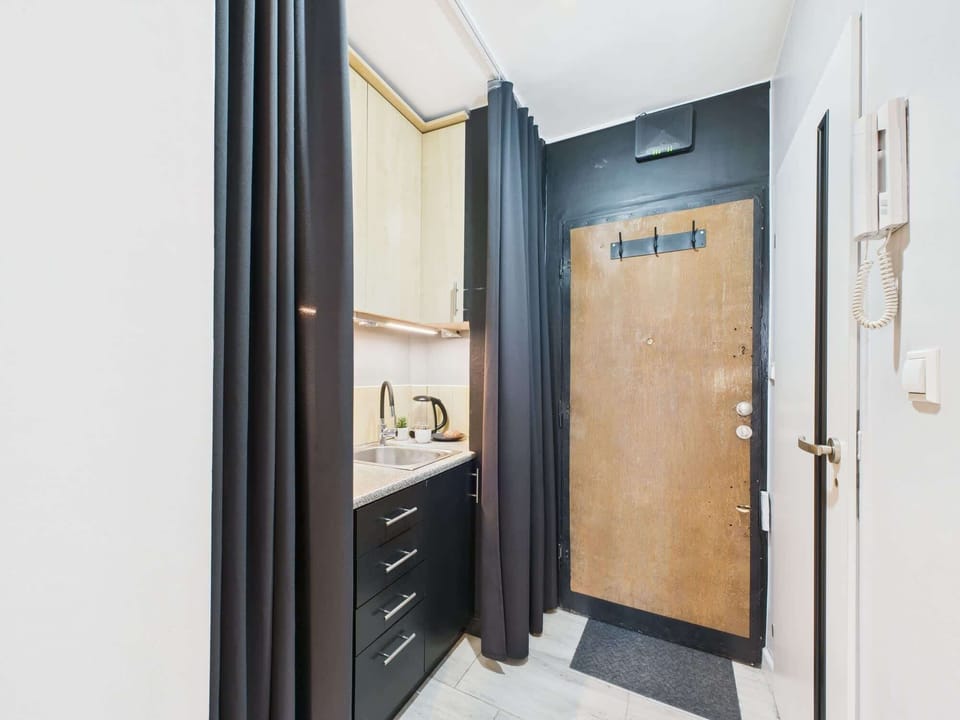 A hallway leading into the main living space, featuring a combination of dark and light colors for contrast.
