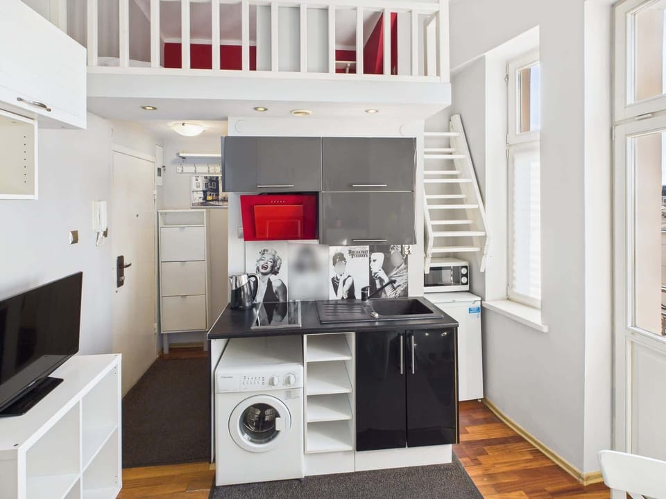 Stove, oven, microwave, and washing machine built into the sleek black-and-white cabinetry.