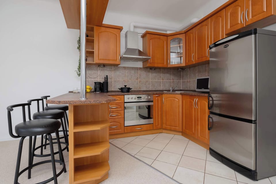 Modern kitchenette with full equipment like oven, stove and a comfortable dining area allows for convenient meal preparation.