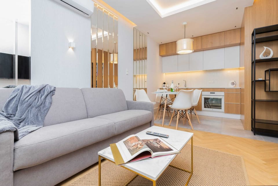 The living area features a sleek coffee table and a flat-screen television.