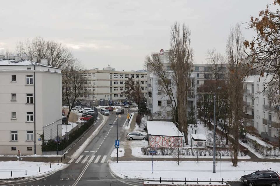 A view from the balcony overlooking the surrounding neighborhood and nearby buildings. The winter scenery creates a calm and peaceful atmosphere.
