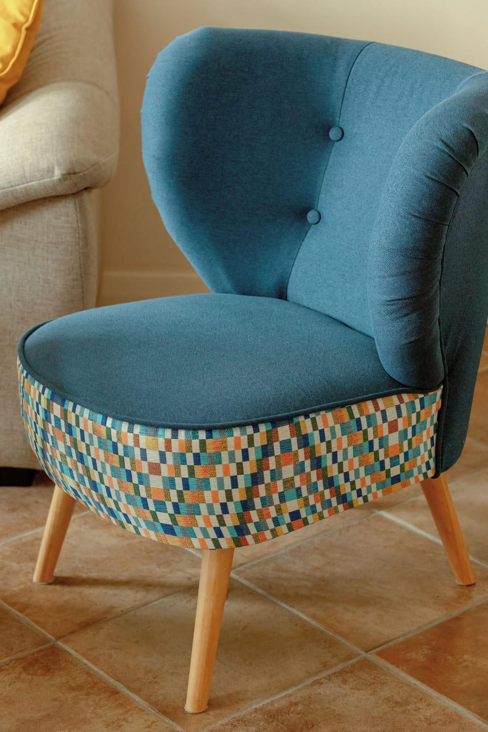 A close-up of a blue armchair with a patterned cushion, adding a pop of color to the room’s decor.