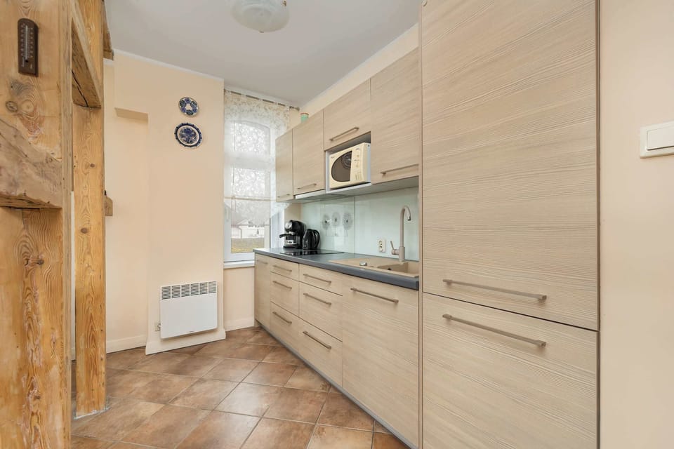 A kitchen corner with wooden elements and a glass backsplash, maintaining a cohesive and functional design.