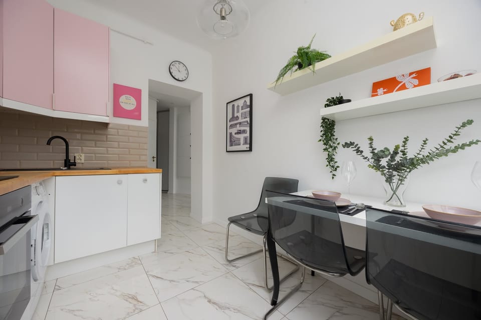 The dining area with designer chairs and open shelves offers an elegant yet relaxed space for meals.