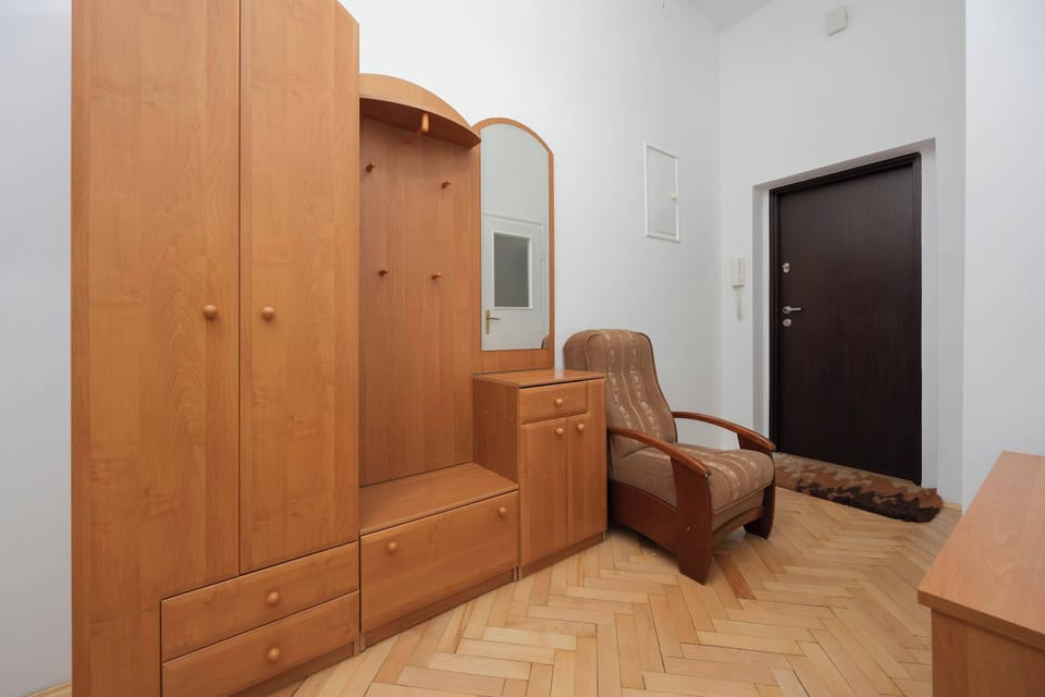 The hallway with closet, mirror, armchair and chest of drawers.