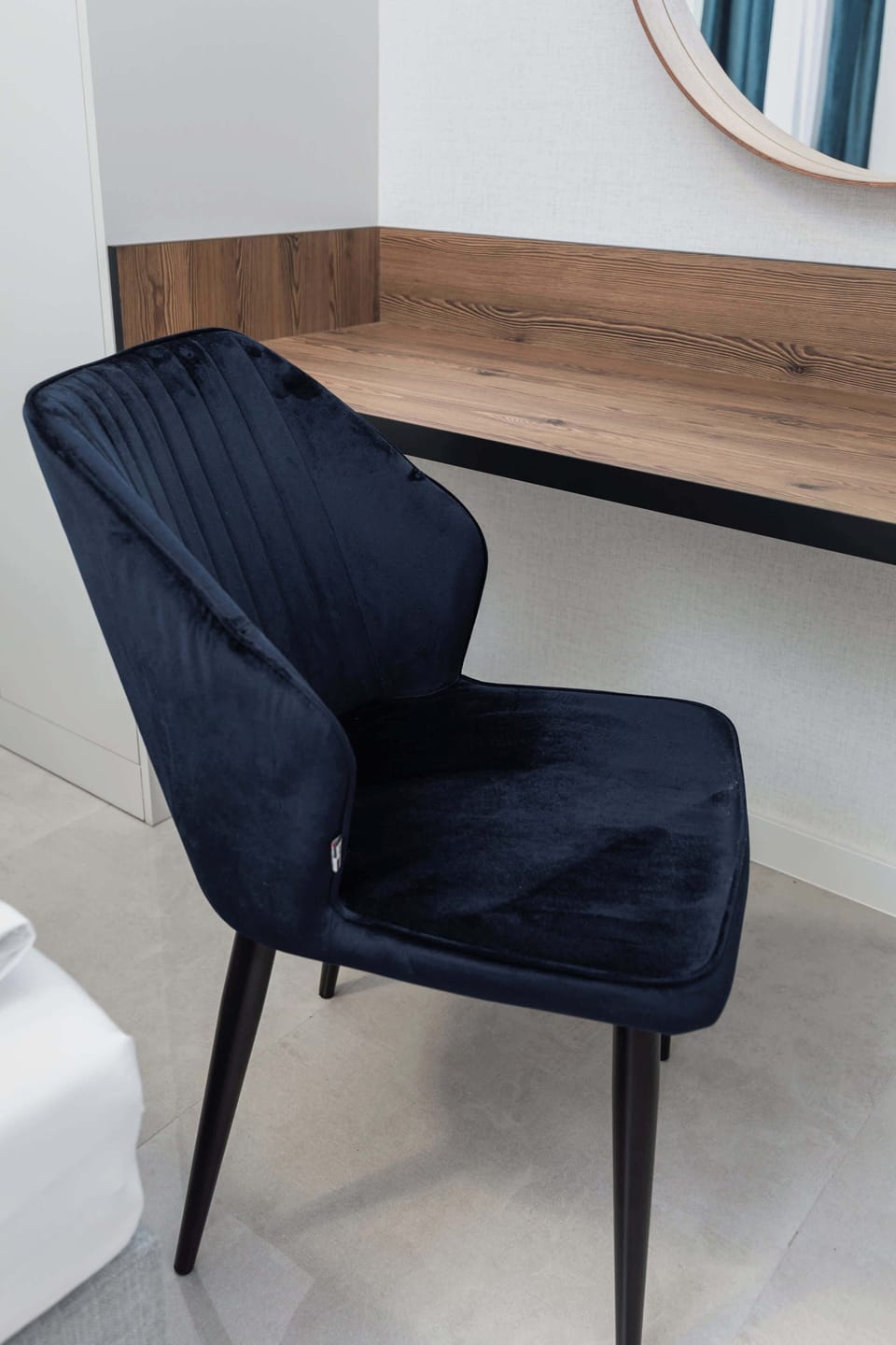 A workspace/vanity area, consisting of a desk and an elegant chair.