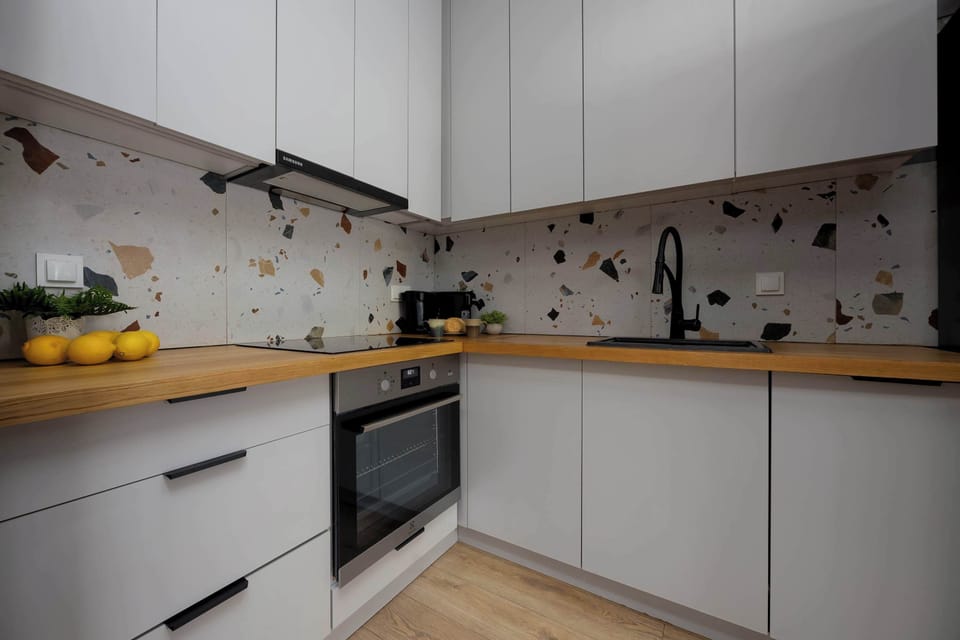 A fully equipped kitchen featuring modern cabinets and patterned backsplash.