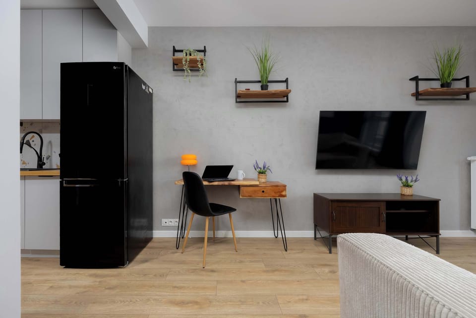 A bright living space with a large TV, open shelves, and contemporary furnishings.