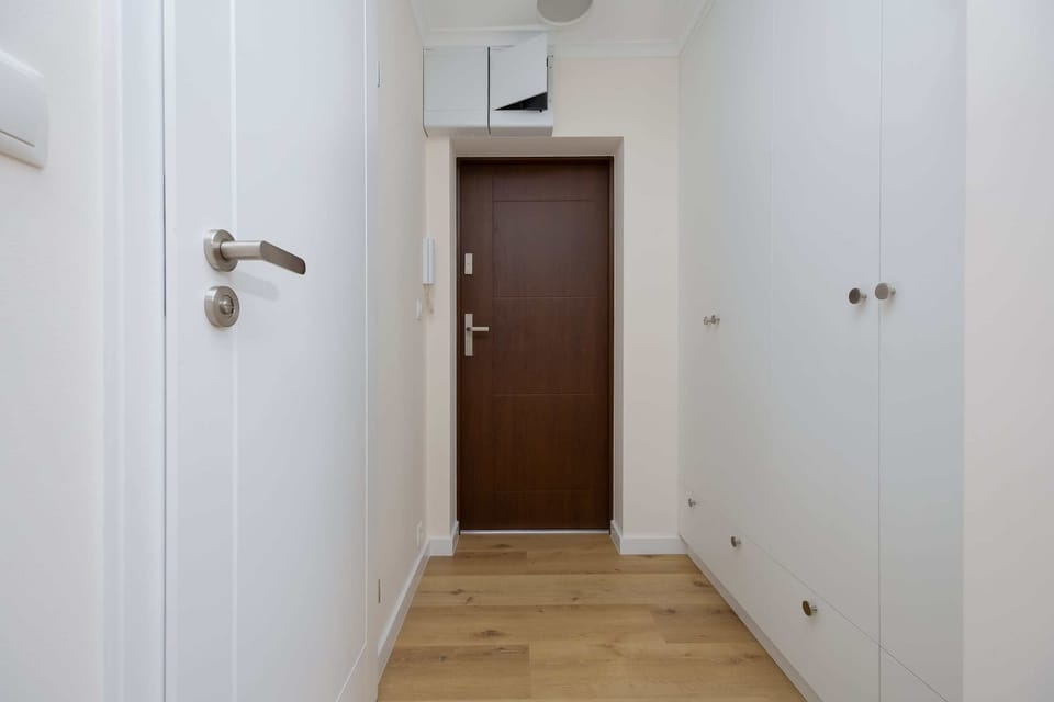 Wooden doors and hallway with capacious cabinets.