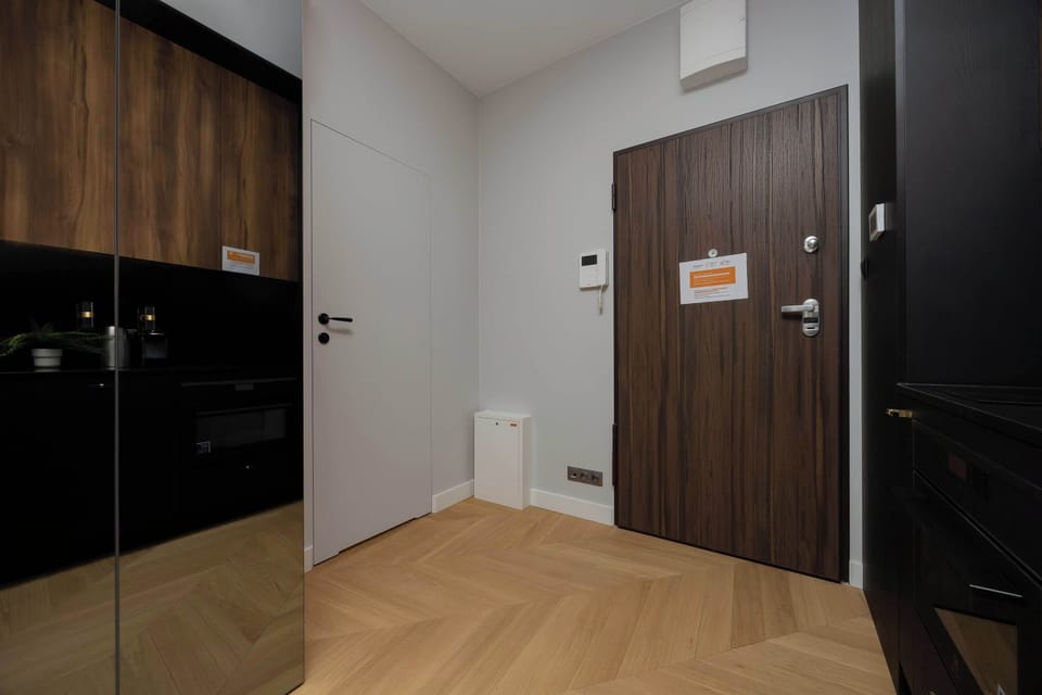 Wooden accents and clean built-in forms create an elegant apartment entrance.