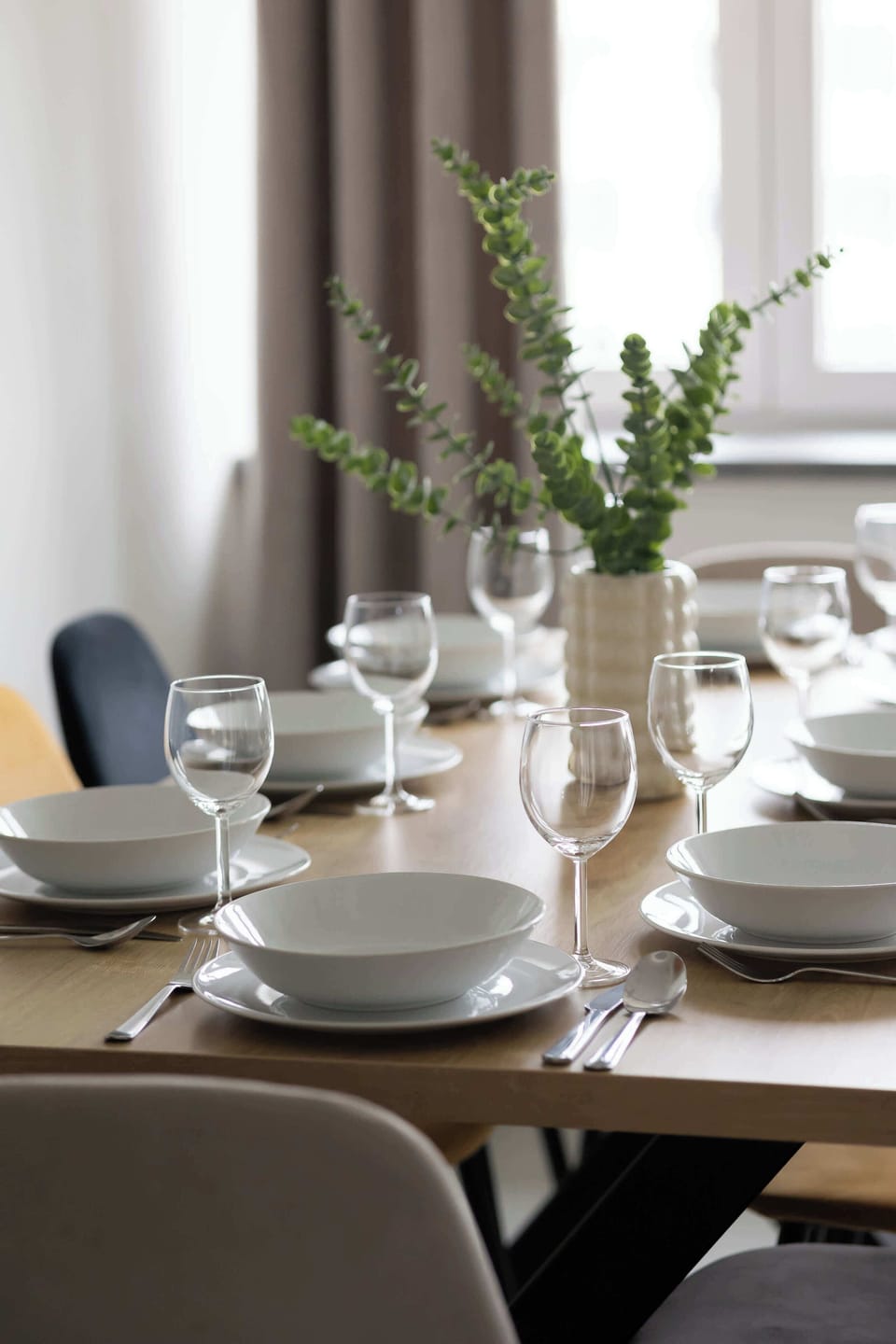 A close-up of the dining table set for a meal, with elegant tableware and decorations.