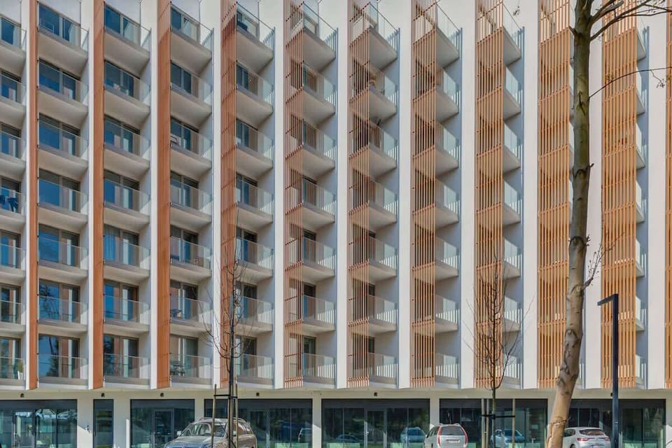 The exterior of a tall, modern apartment building with a unique grid-like design.