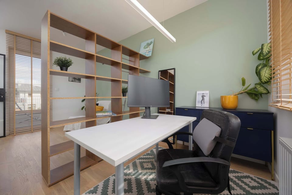 A modern home office with a spacious desk and practical bookcases.