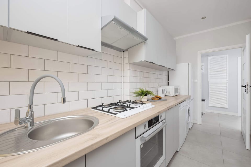 Kitchen with gas stove, oven, dishwasher, microwave, fridge and freezer and electric kettle.