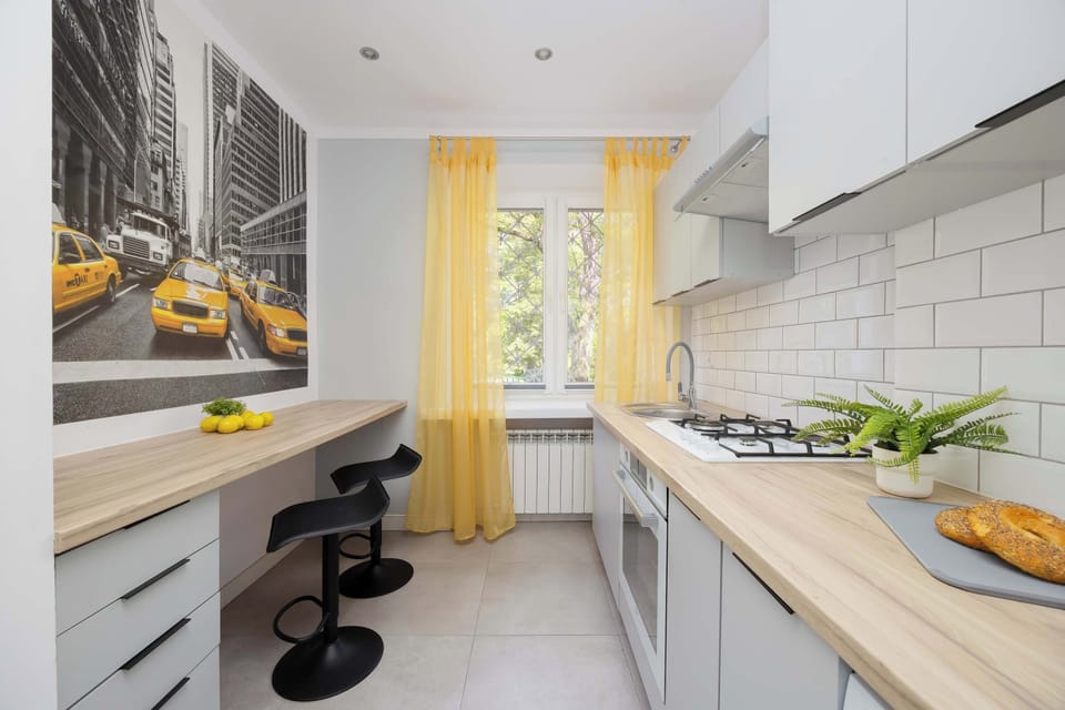 Fully equipped and modern kitchen with bright cabinets and dining area with high chairs.