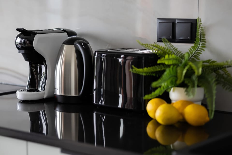 A coffee nook with an espresso machine, kettle, and toaster makes every morning easier.