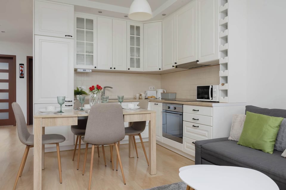 A clean, elegant kitchen and dining area in soft tones. Features a functional layout and high-quality finishes.