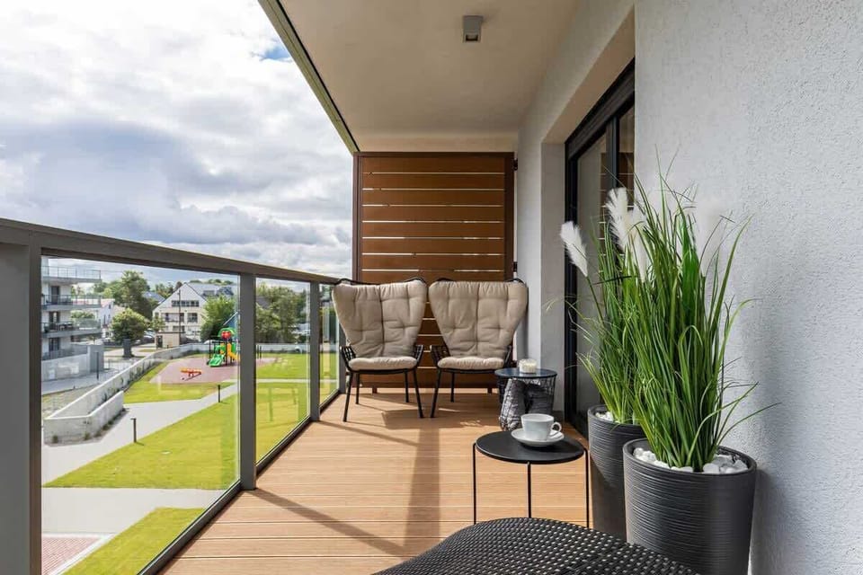 Furnished balcony with green surroundings. 