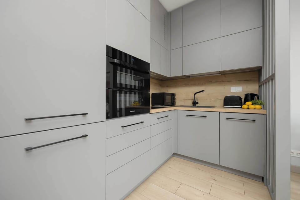 The kitchenette with custom cabinetry and black accents offers comfortable cooking conditions.