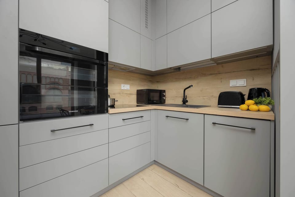 The kitchen with grey built-in cabinets combines style and full functionality for everyday cooking.
