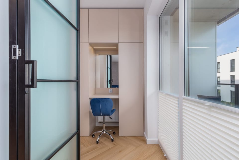 A stylish corner of the bedroom with a desk by the window, offering a cozy workspace with natural light.

