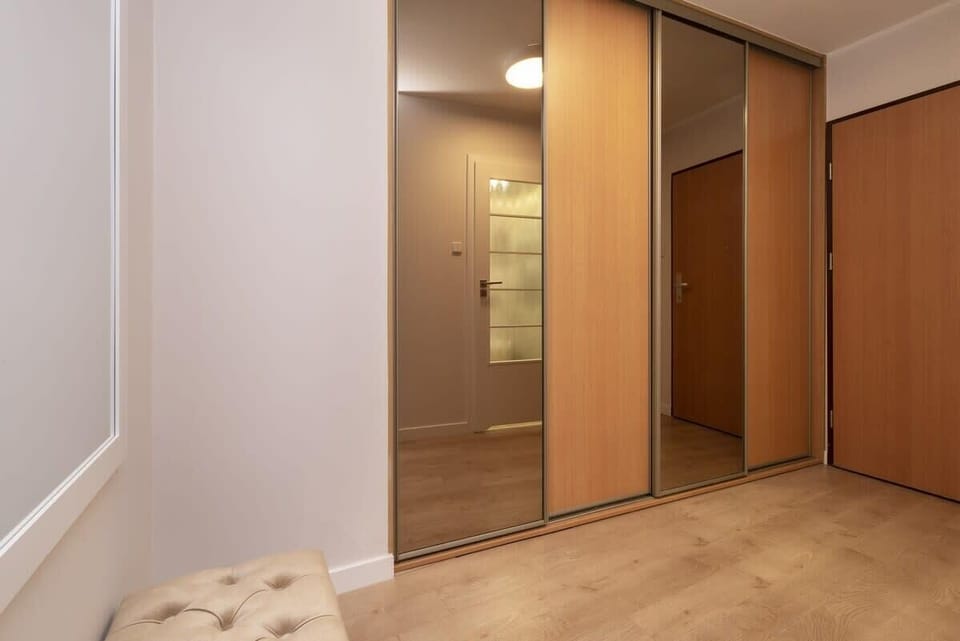 Entry area with built-in wooden wardrobes and a well-lit space.

