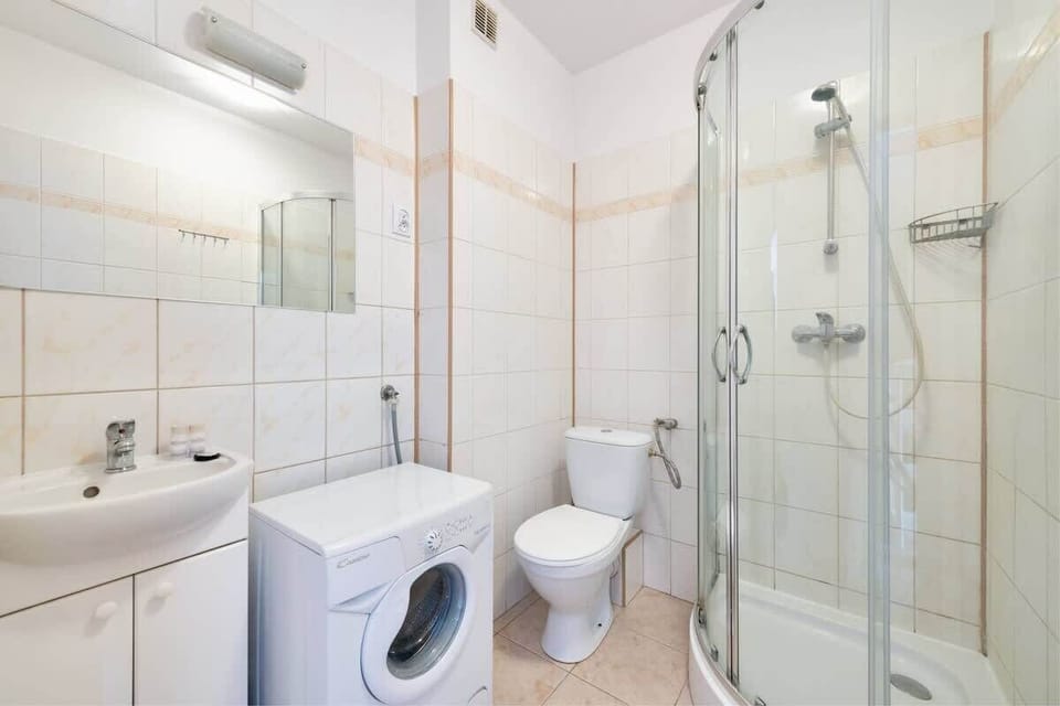 The bathroom, done in bright colors, is equipped with a shower, toilet, sink and mirror.  