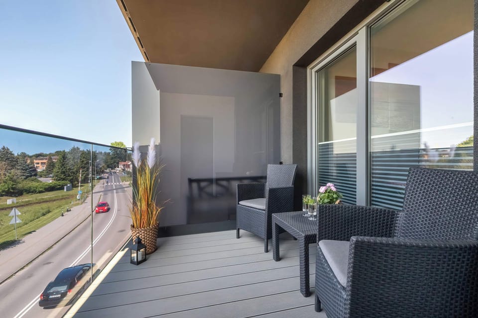A balcony space with two dark wicker armchairs and a small table, overlooking the surrounding area, ideal for unwinding.

