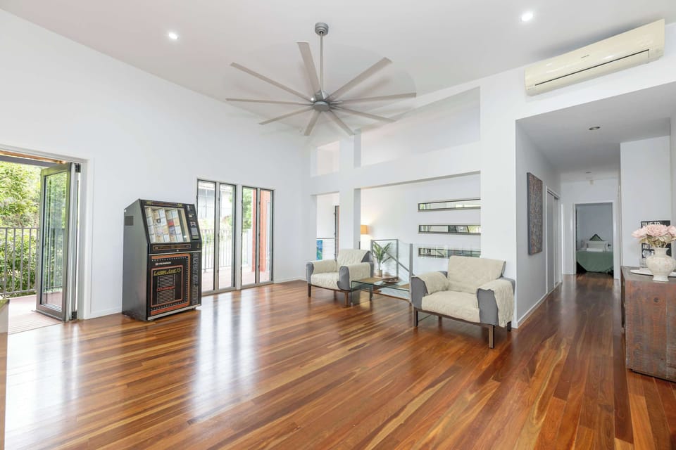 Open-plan living area with timber floors and air conditioning