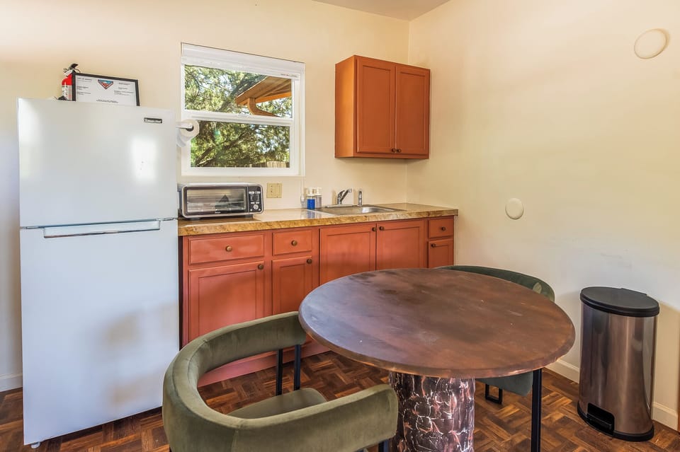 Kitchenette w/ refrigerator, Ninja toaster oven air fryer, pots, and dishes.