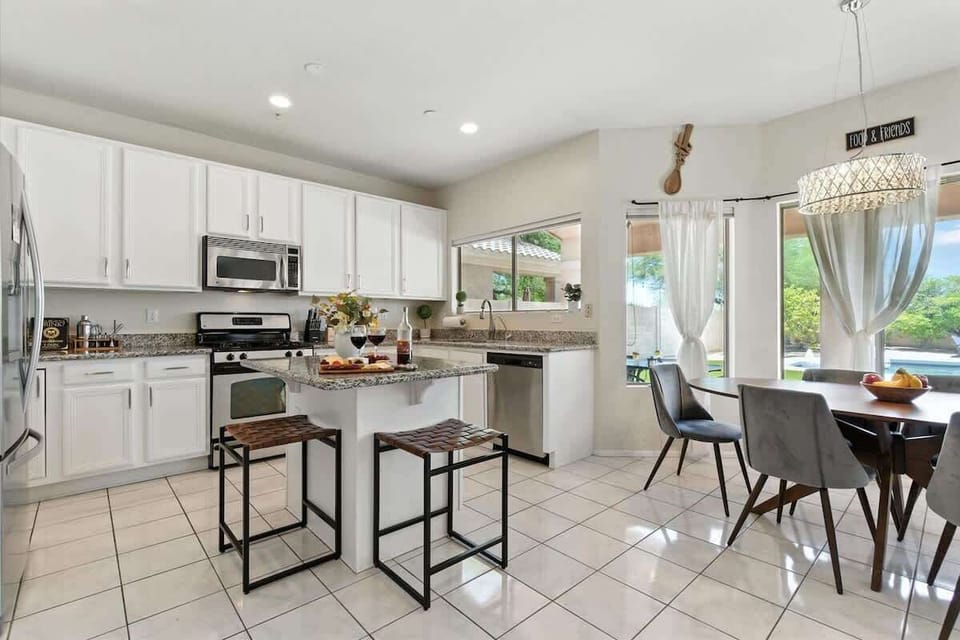 The fully equipped modern kitchen is stocked with all culinary essentials, stainless-steel appliances, and breakfast bar seating. (1st Floor)