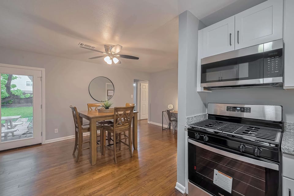 Dining Area: Enjoy meals at a spacious table with views of the lush backyard! Perfect for gatherings.