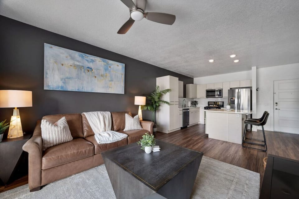 Beautifully designed living room. 65` TV, leather sofa and amazing views of mountains and city skyline.