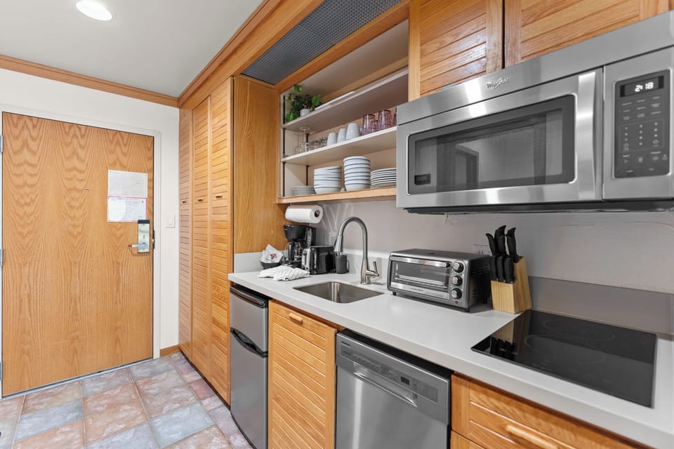 Whip up your favorite meals in this modern kitchen featuring warm wood cabinets, stainless steel appliances, and everything you need for a comfortable stay.