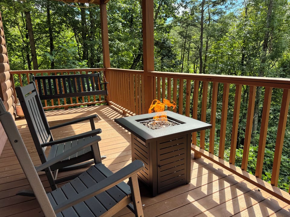 Cozy lower deck with rocking chairs, porch swing, and fire pit.