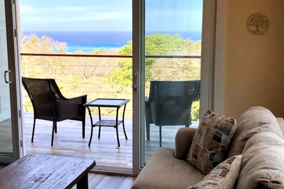 “Step outside to your private patio balcony—outdoor seating for two with a coffee table, the perfect spot for morning coffee or evening cocktails with your loved one and Caribbean views