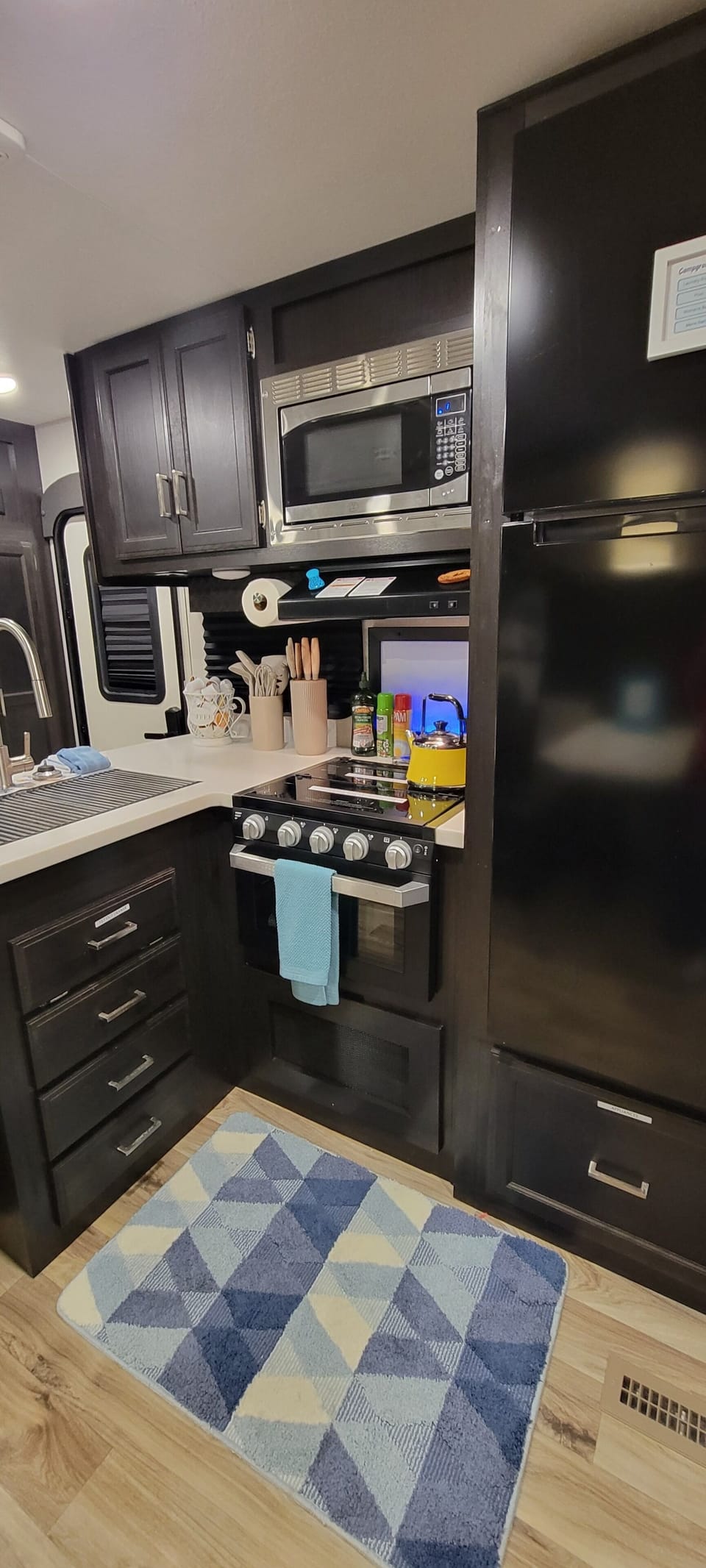 Full kitchen with residential refrigerator, cooktop, oven and microwave