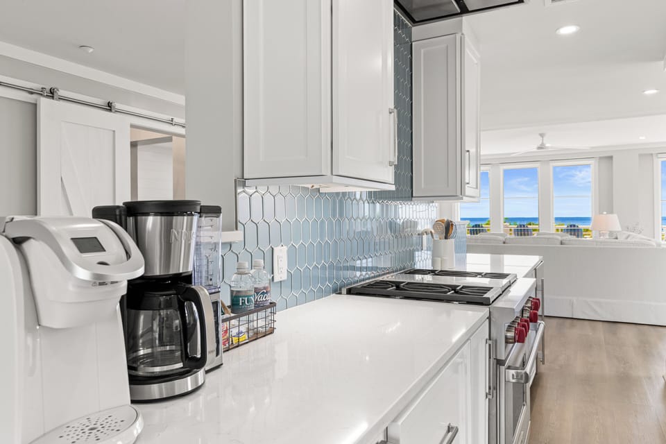 Prepare delicious meals in your sleek, modern kitchen featuring granite countertops, premium appliances, and stunning ocean views.