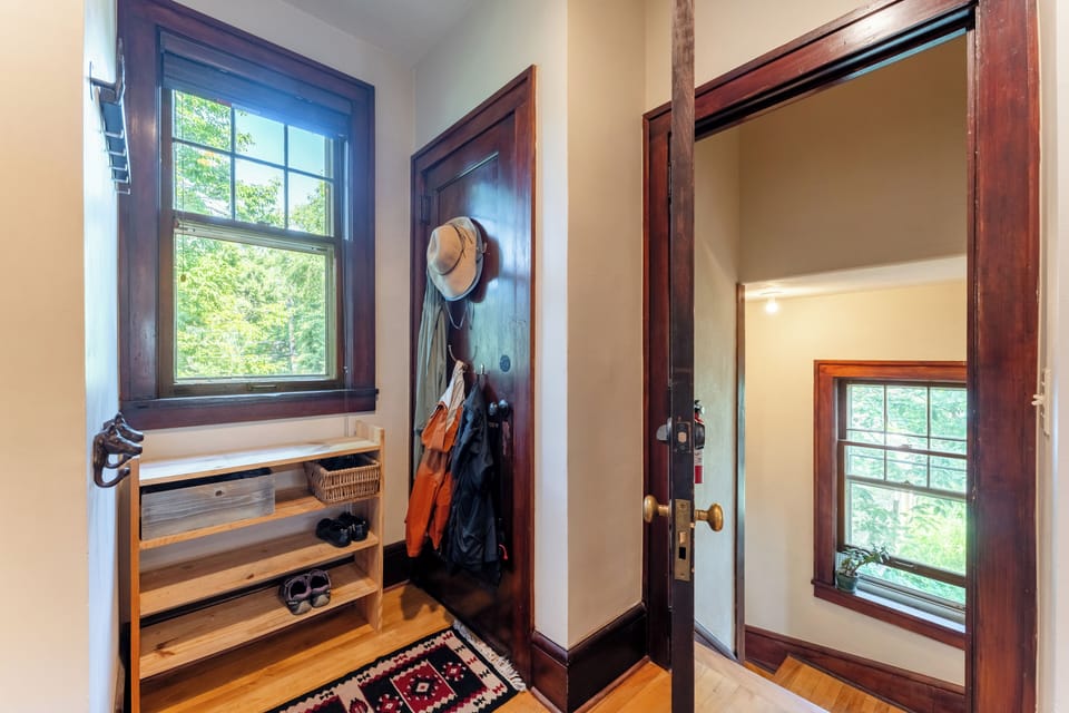 Back entry with shoe shelves and coat hooks. Stairs to exterior patio