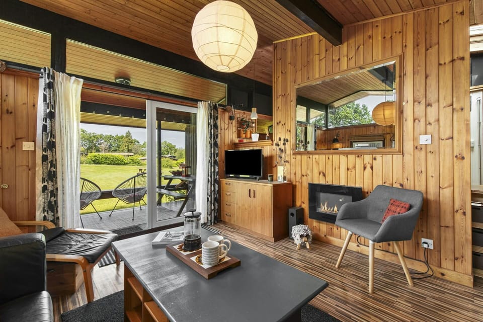 Chairs, coffee table, unit with TV, patio doors to the garden seating area