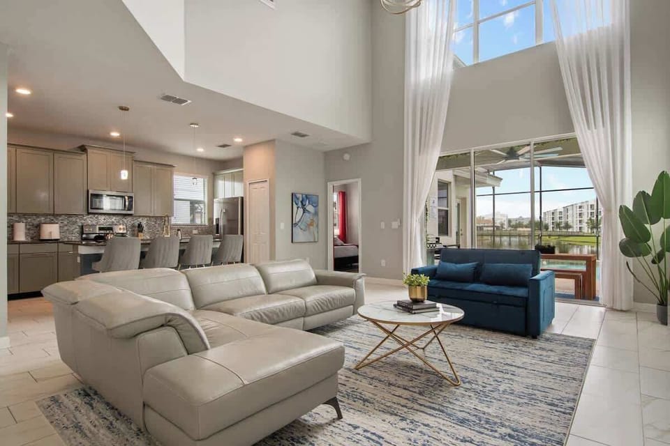 Experience comfort and style in this airy living space with floor-to-ceiling windows, cozy sofas, and calming natural light, offering the perfect spot to relax and connect.