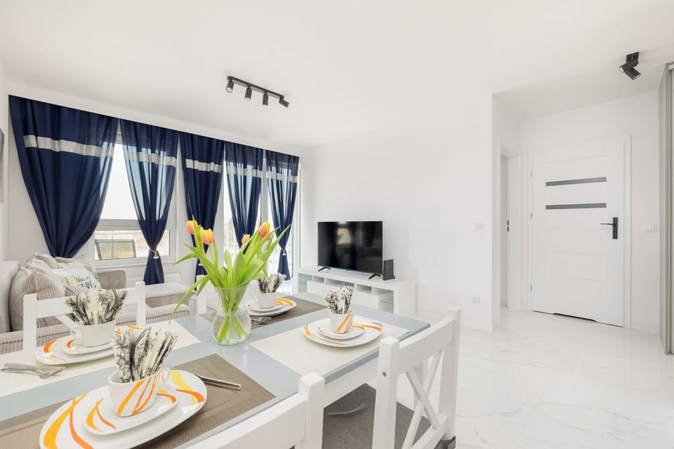 A cozy living space with a table set for dining and a view of the sofa.
