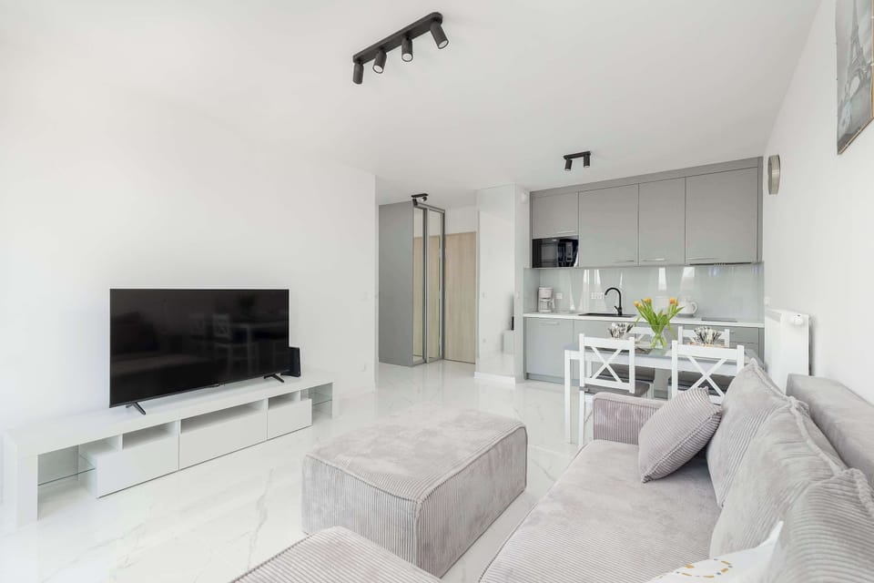 A modern living area with a mounted TV and a stylish sofa.
