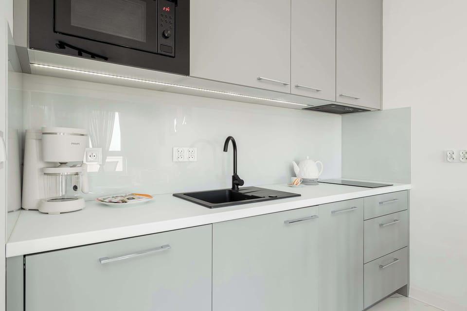 A close-up of the kitchenette with white cabinets.
