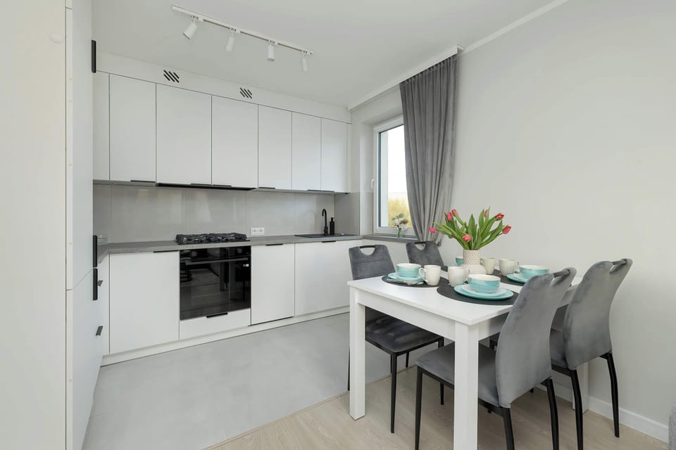 Dining table for four with modern lighting – Ideal for shared meals or working remotely.