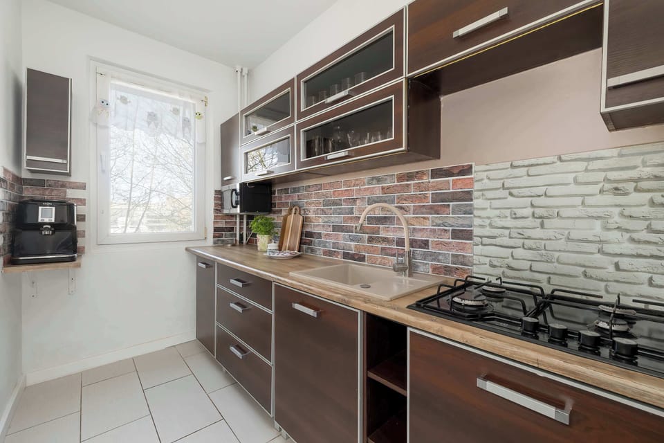 The kitchen is equipped with essential items such as an oven, gas stove, coffee maker, and even has an ice cube maker and electric grill.