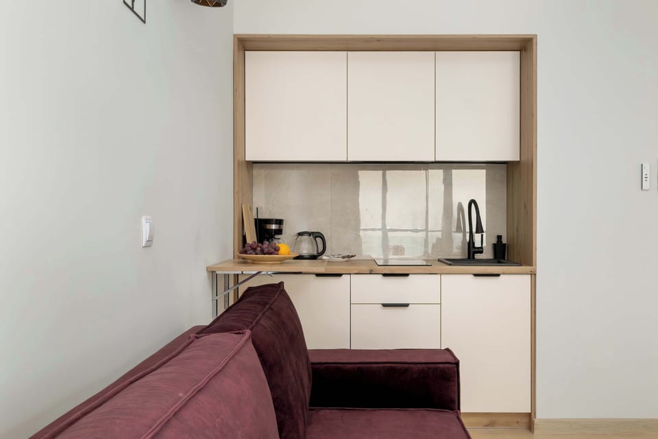 Compact kitchenette and sofa in one shot – functional and open-plan living.