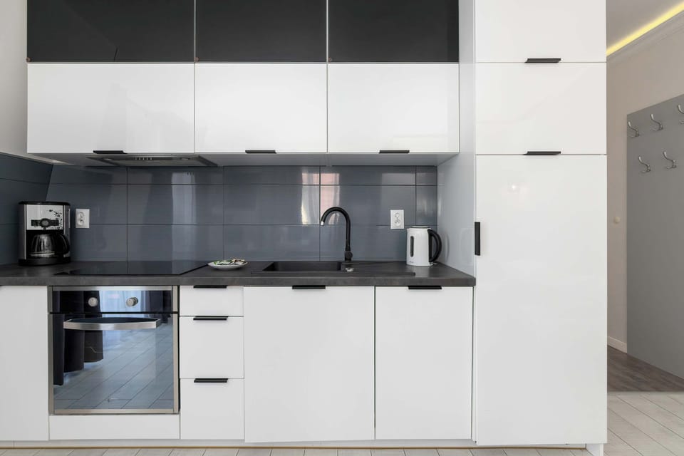 Stylish kitchenette equipped with modern appliances, including cabinets for convenient storage.